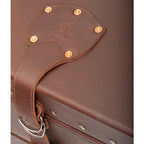Leather Trunk in Chestnut, close-up of riveted lid strap with embossed Saddleback Leather Co. logo and D-ring