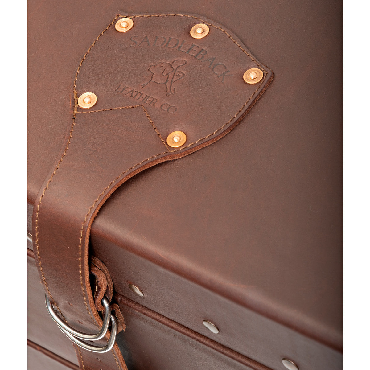 Leather Trunk in Chestnut, close-up of riveted lid strap with embossed Saddleback Leather Co. logo and D-ring