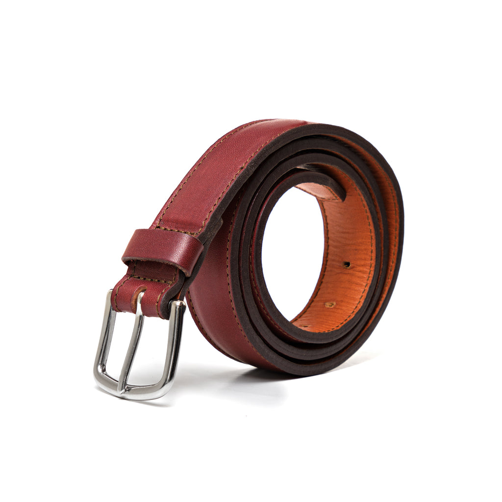 Italian Dress Belt in Oxblood, coiled to show the silver buckle and tan underside