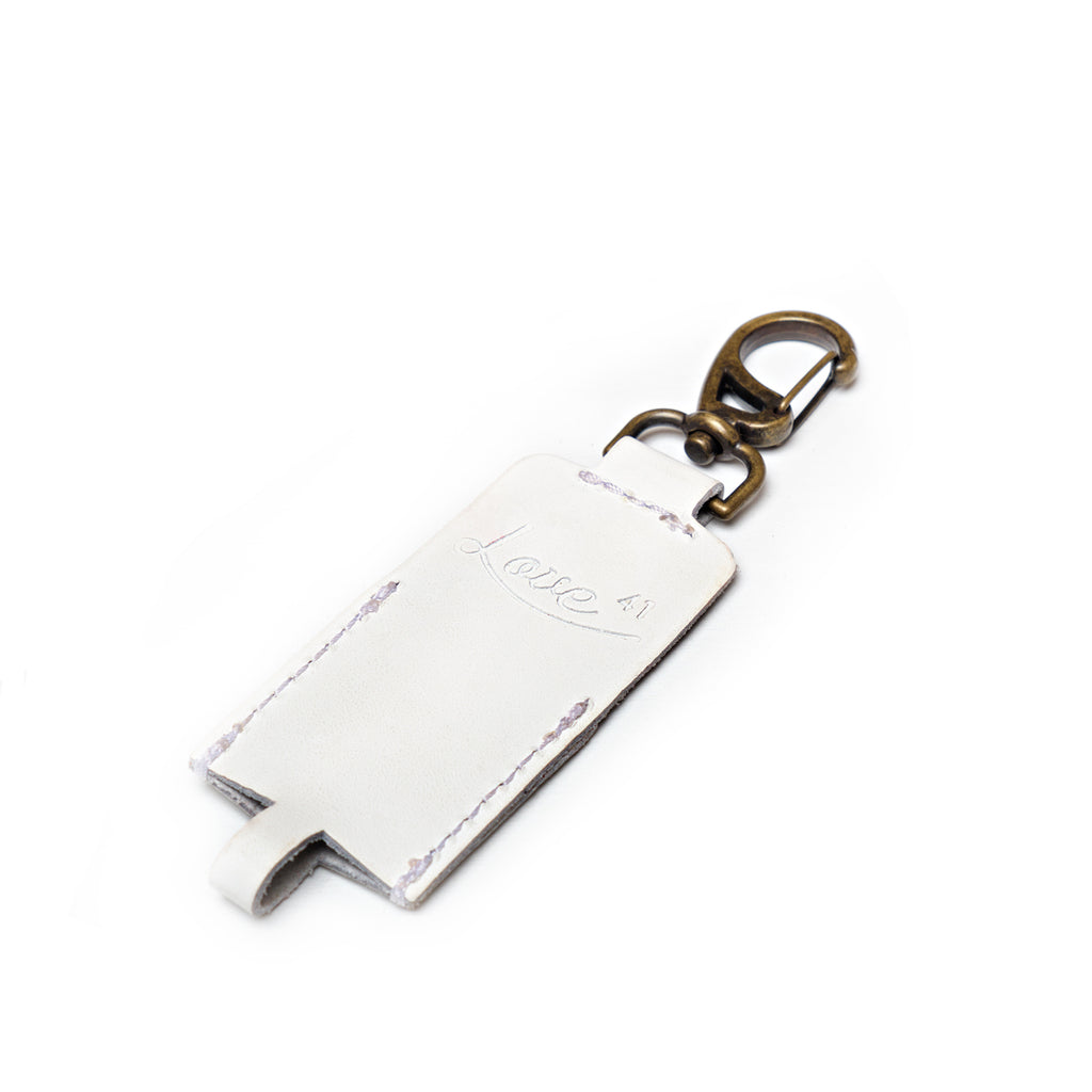 Leather Chapstick Holder in white, empty front view with embossed Love 41 logo and brass clasp