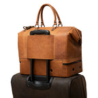 Two Compartment Duffle in Tobacco, back trolley sleeve slid over a rolling suitcase handle