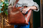 Concealed Carry Leather Tote in Chestnut, hand reaching into the zippered concealed carry compartment