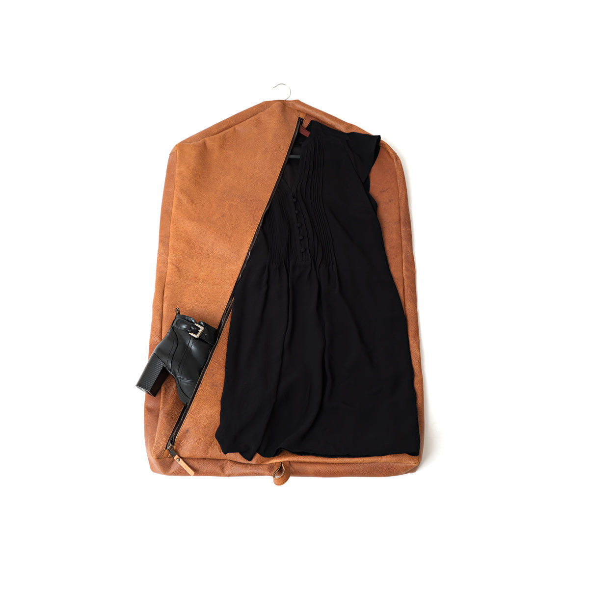 Garment Bag in Tobacco unzipped to show a black dress and heeled boots inside