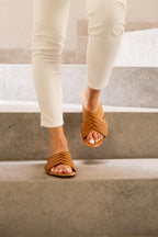 Martha Sandals in Tobacco worn with cream pants while walking down concrete steps