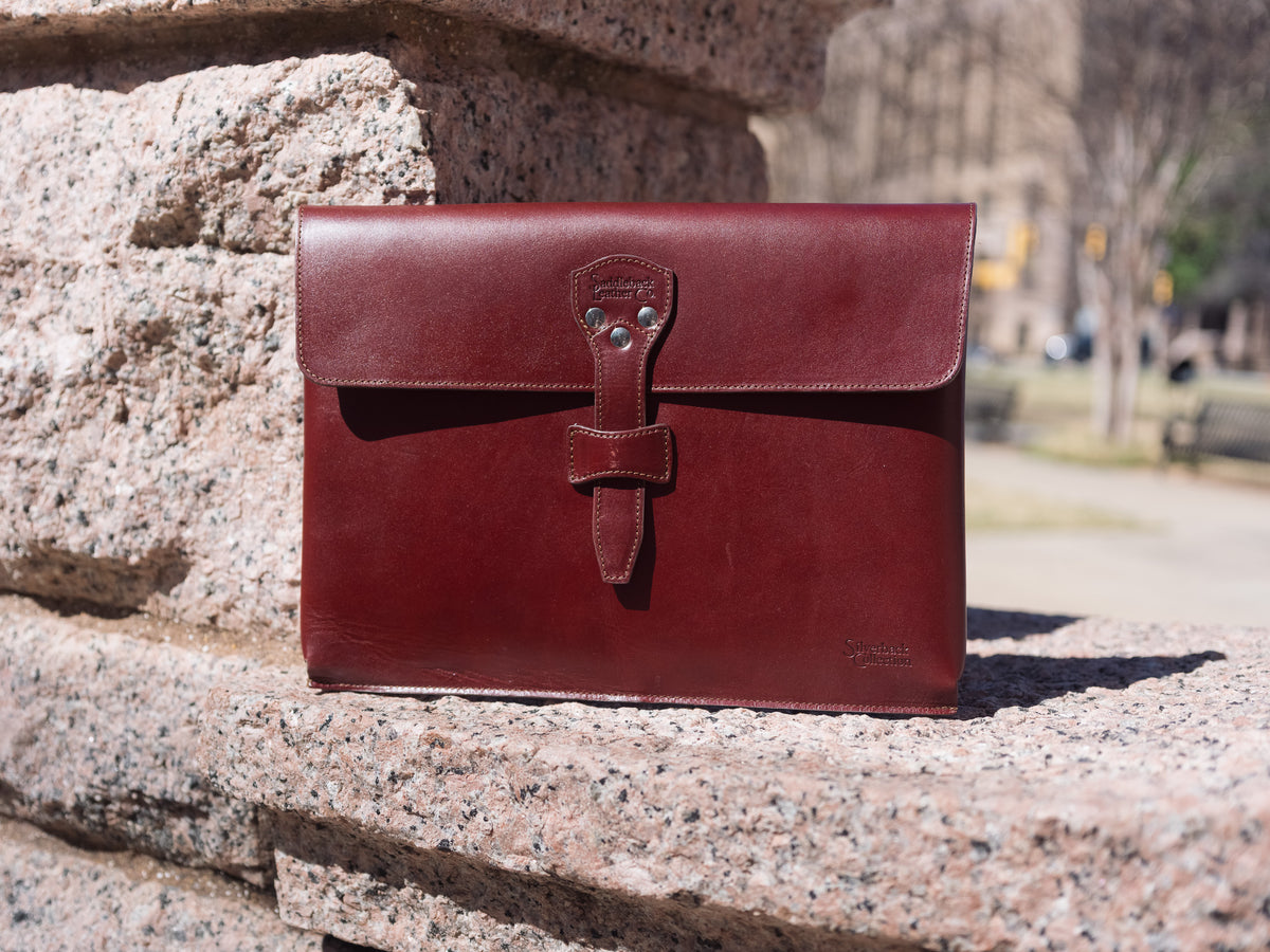 Silverback Document Holder in Oxblood, standing on a granite ledge outdoors in sunlight