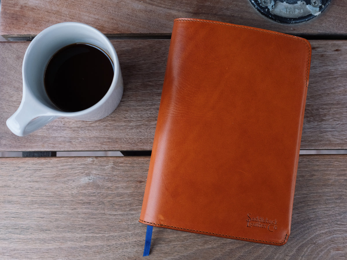 J.R.R. Tolkien Journal Cover in English Tan, closed on a wooden table beside a mug of coffee