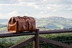 Wesley Deep Pocket Duffle in English Tan on a wooden fence overlooking Italian hills