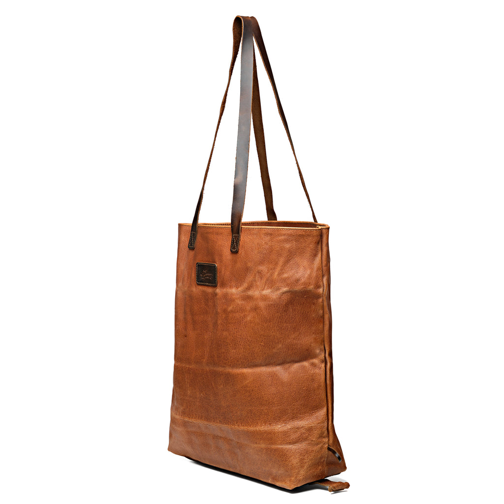 Travel Tote in Bacon, angled side view with leather logo patch and dark shoulder handles