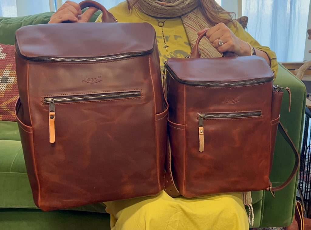 All in One Backpack Medium in Chestnut held beside the larger size for a size comparison