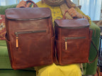 All in One Backpack Medium in Chestnut held beside the larger size for a size comparison