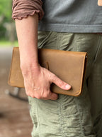 New Big Wallet in Tobacco carried in one hand at the side, back view