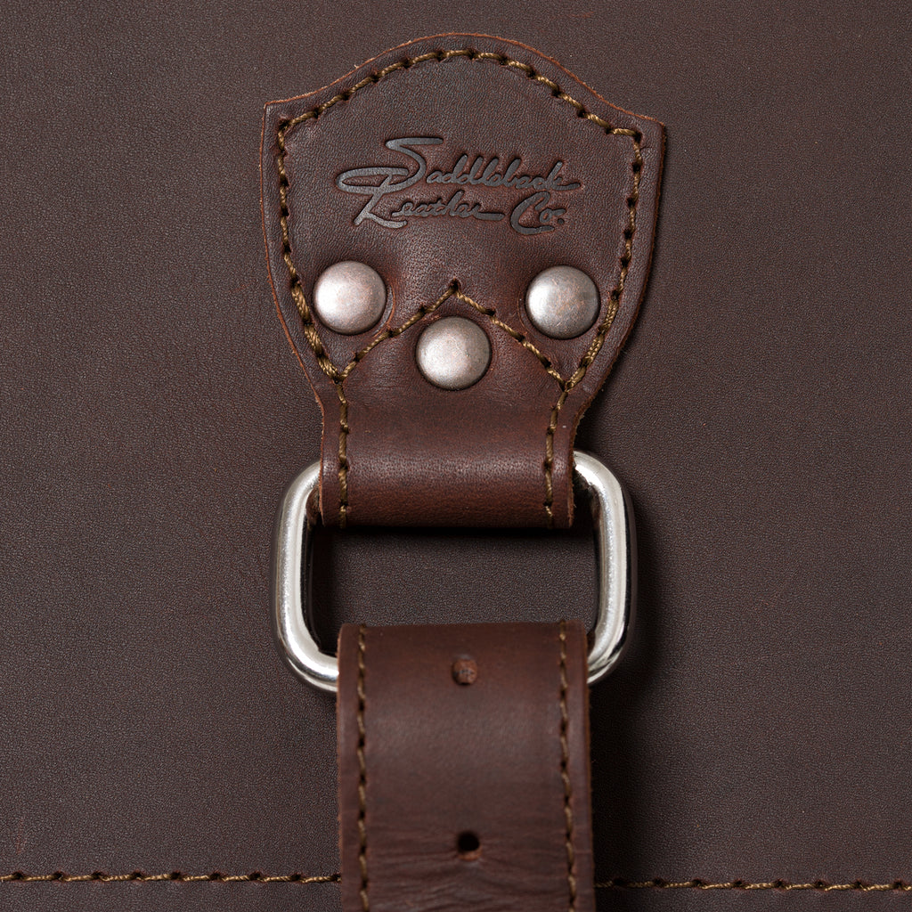 27" Adolescent Beast Duffle Bag in Chestnut, close-up of the embossed logo tab, rivets and D-ring strap