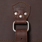 27" Adolescent Beast Duffle Bag in Chestnut, close-up of the embossed logo tab, rivets and D-ring strap
