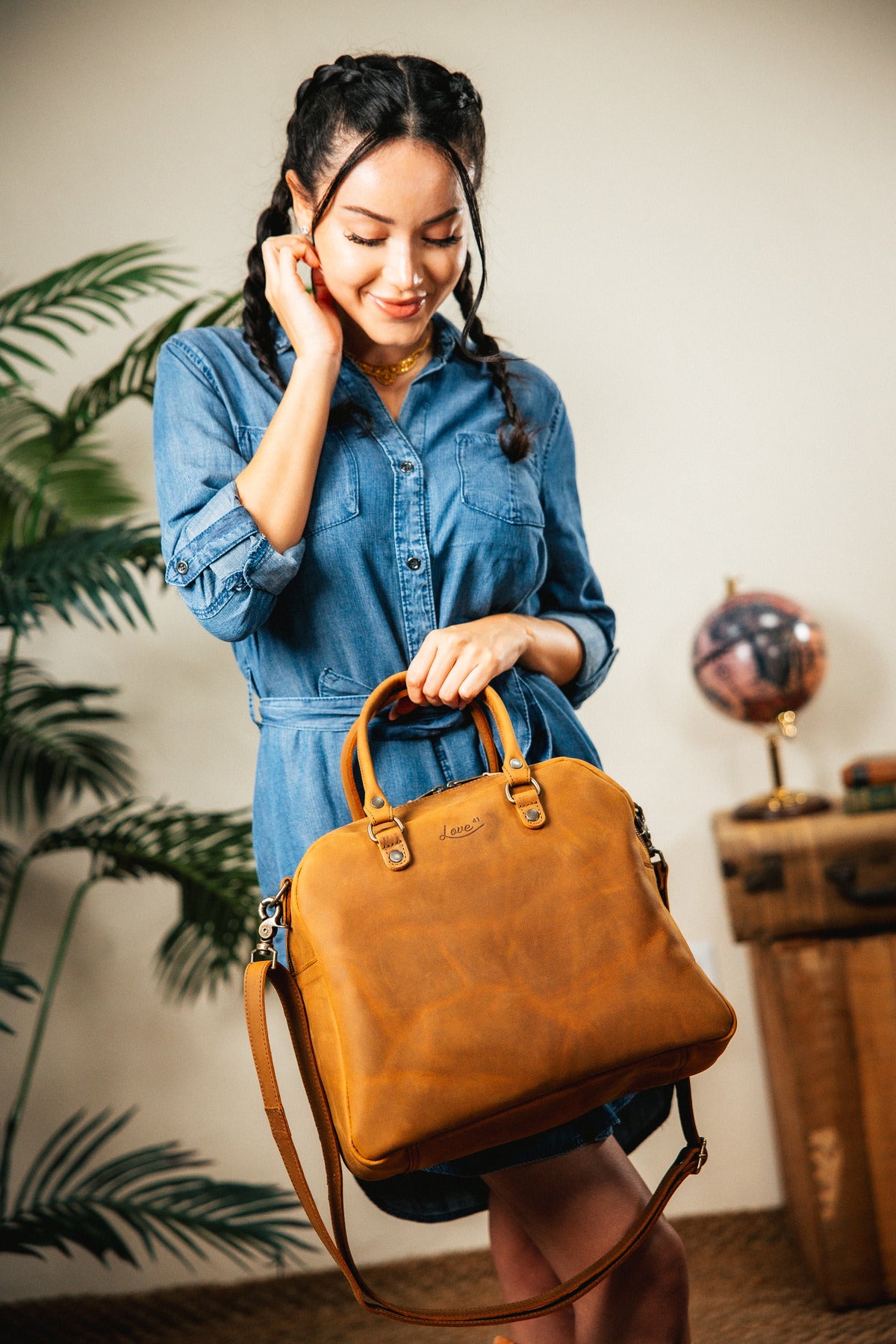 Professional Leather Satchel in Tobacco, held by the top handle by a smiling woman in a denim dress