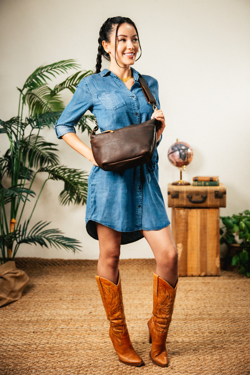 London Sling Small in Dark Coffee Brown, worn crossbody by a woman in a denim dress and cowboy boots