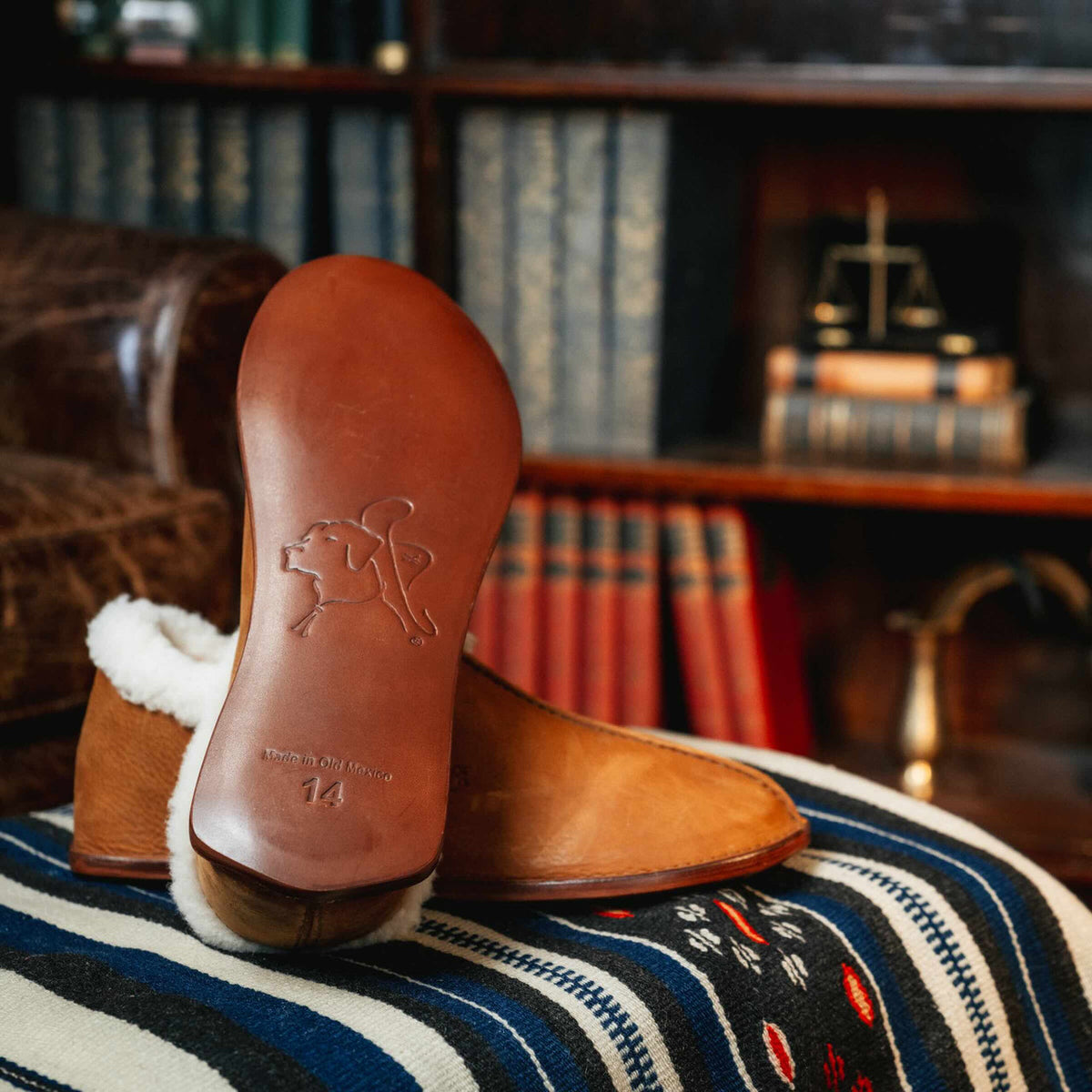 Sheepskin Moccasins in Tobacco on a striped blanket, showing the stamped leather sole