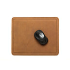 Mouse Pad in Tobacco leather with a black wireless mouse, overhead view showing stitched edges