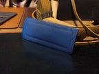 Freedom Collection Extra Shoulder Pad in Blue, propped on a desk beside a tan leather bag