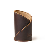 Pen Cup in Dark Coffee Brown leather, front view of the empty cup with diagonal stitched wrap and embossed logo