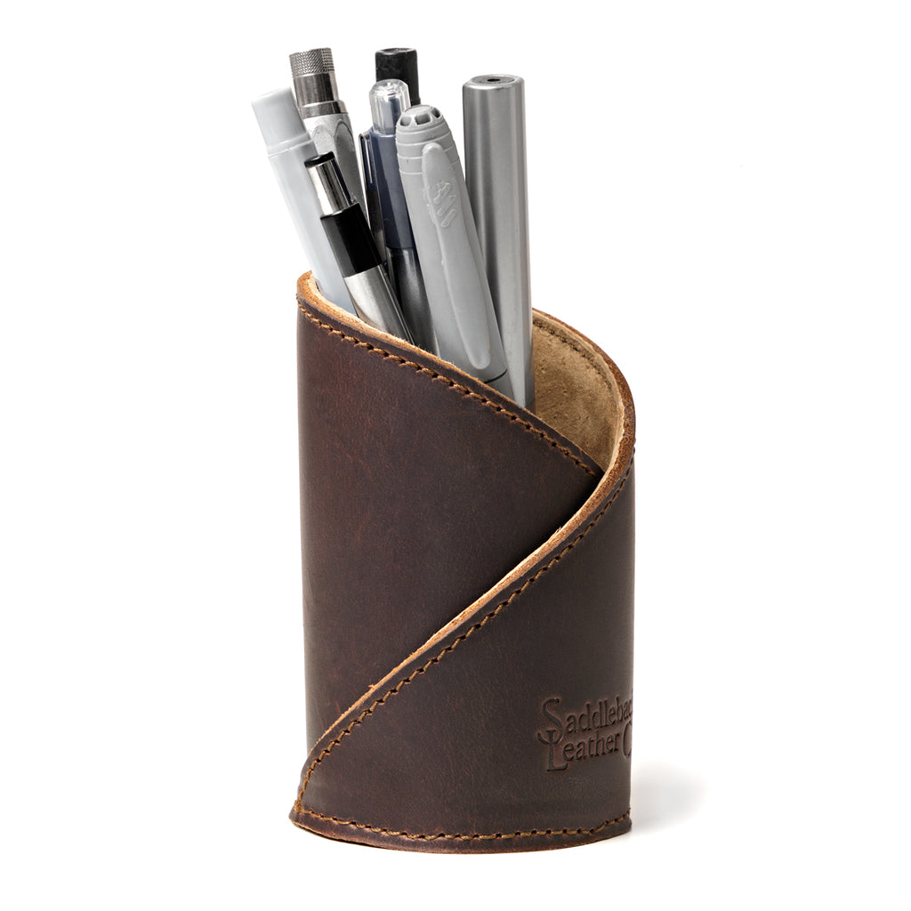 Pen Cup in Dark Coffee Brown leather, front view showing the diagonal stitched wrap and embossed logo, holding pens