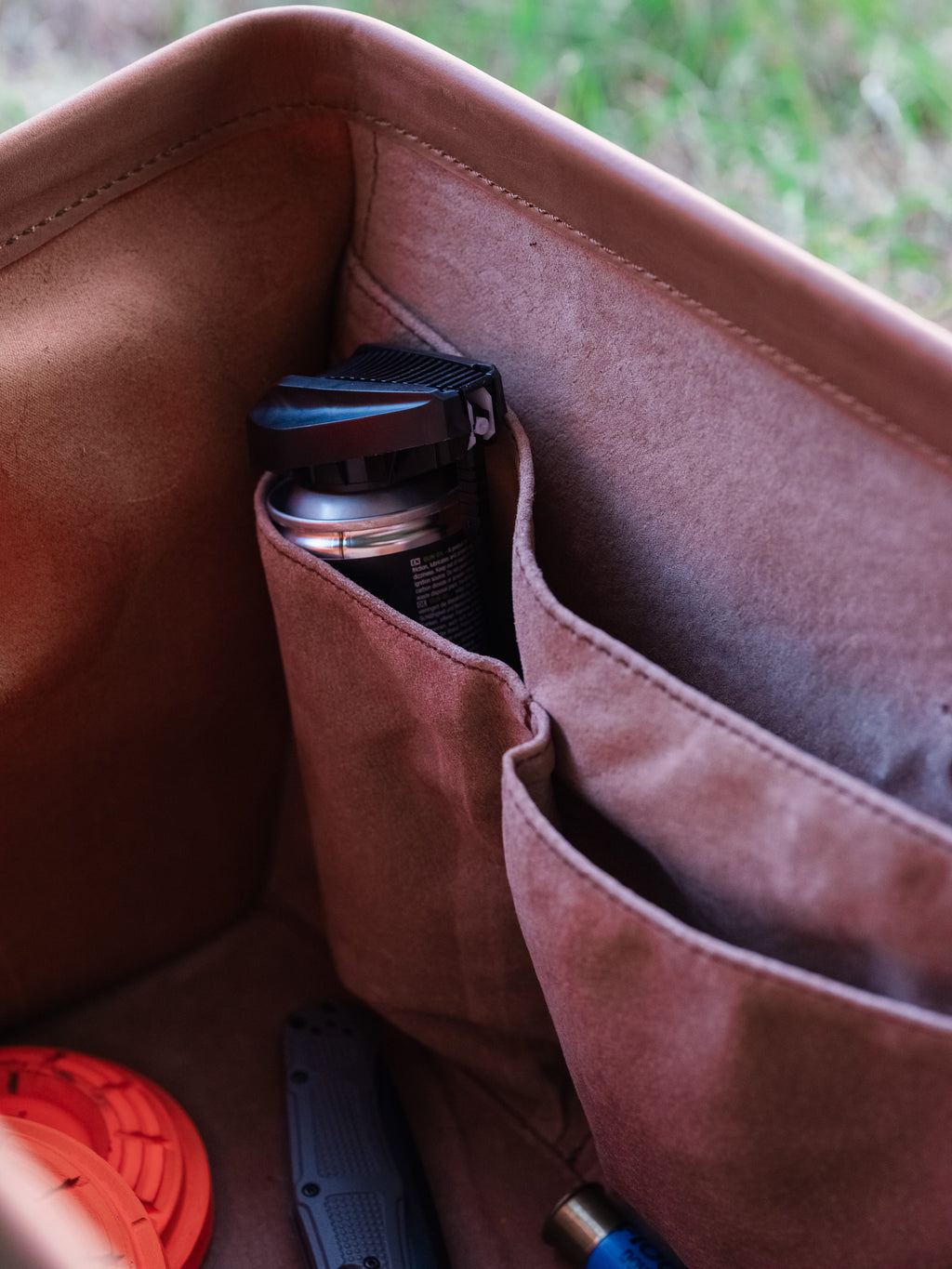 Leather Range and Tool Bag, close-up of the interior slip pockets holding an insulated bottle and range gear
