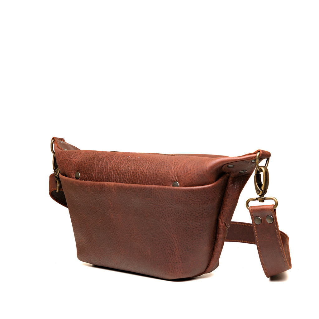 London Sling Small in Chestnut, angled side view showing the front pocket and strap clip