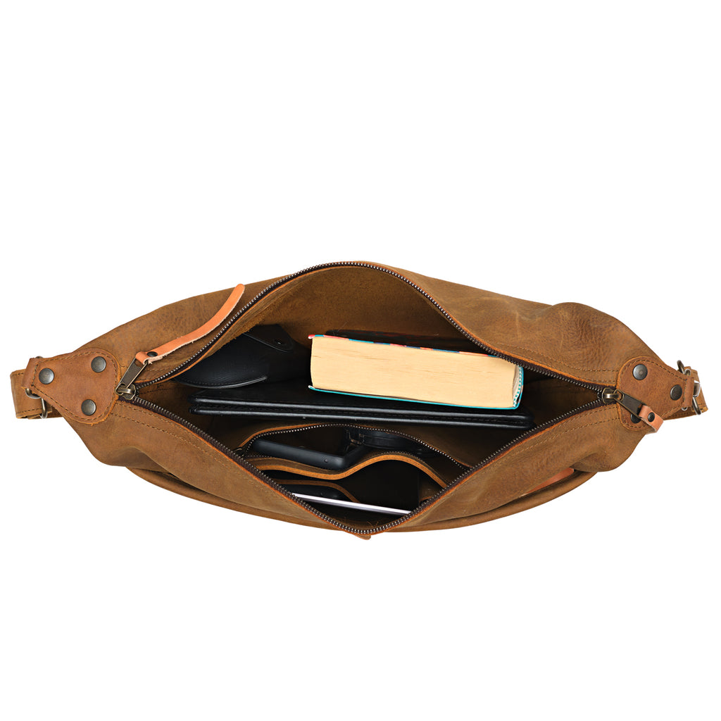London Sling Large in Tobacco, top view unzipped with a book, tablet and sunglasses inside