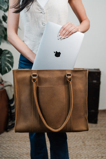 Women's Work Tote in Tobacco with a woman sliding a laptop into it