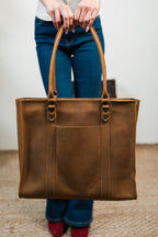 Women's Work Tote in Tobacco held in front by a woman in jeans and red shoes