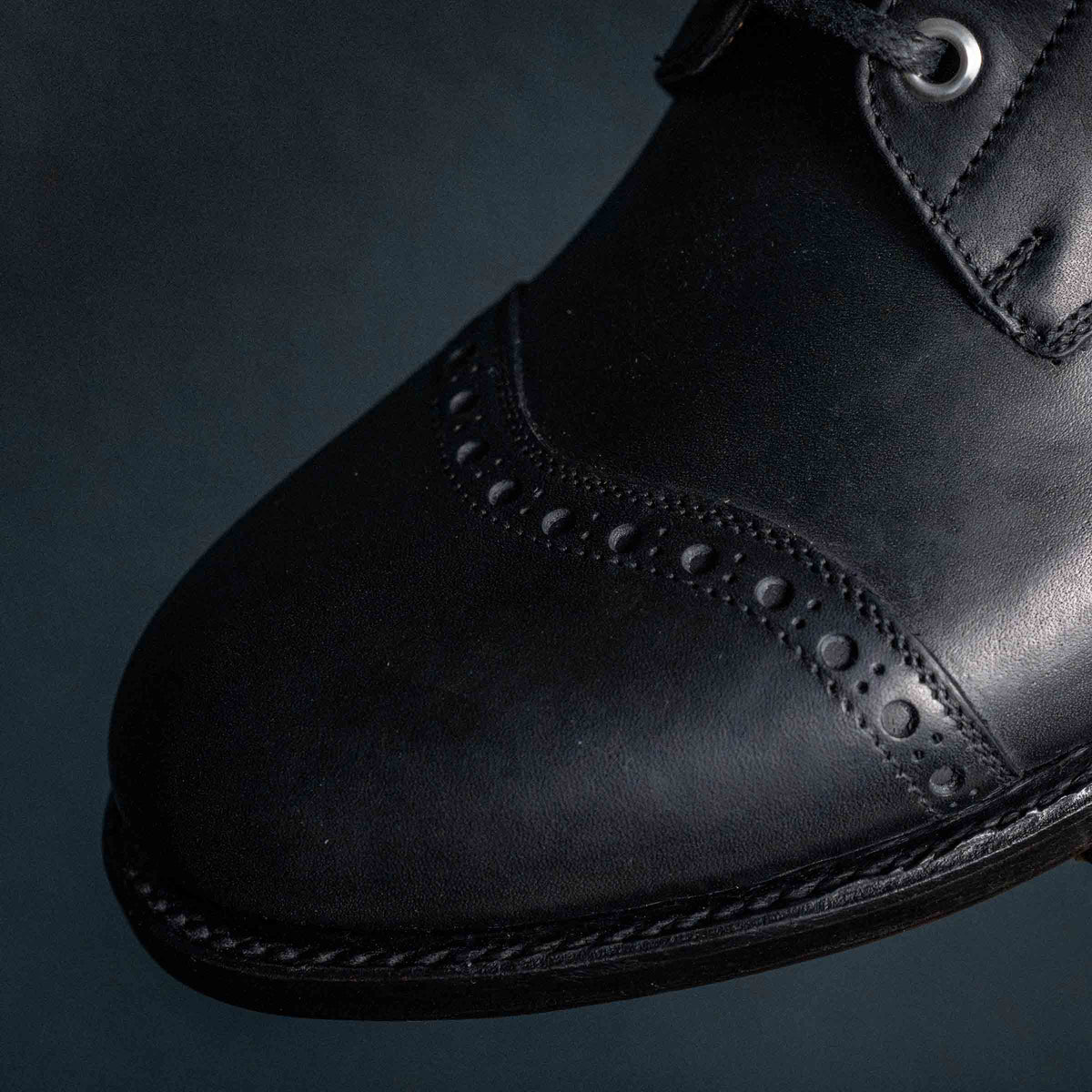 Officer's Boot in Raven Black, close-up of the toe cap perforations and welt stitching