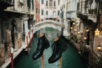 Officer's Boot in Raven Black, pair on wooden stands above a Venice canal