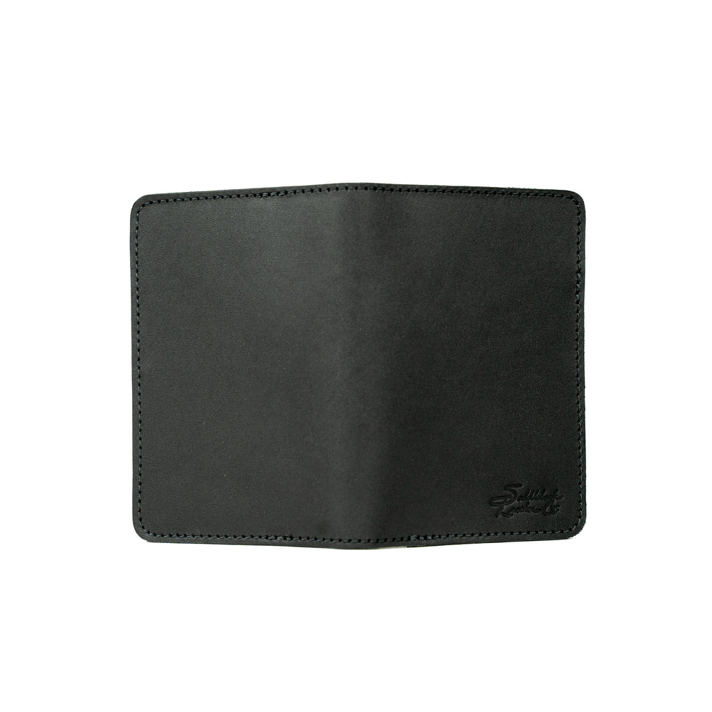 Slim Passport Wallet in Black opened flat face down, showing the full outer cover and embossed logo