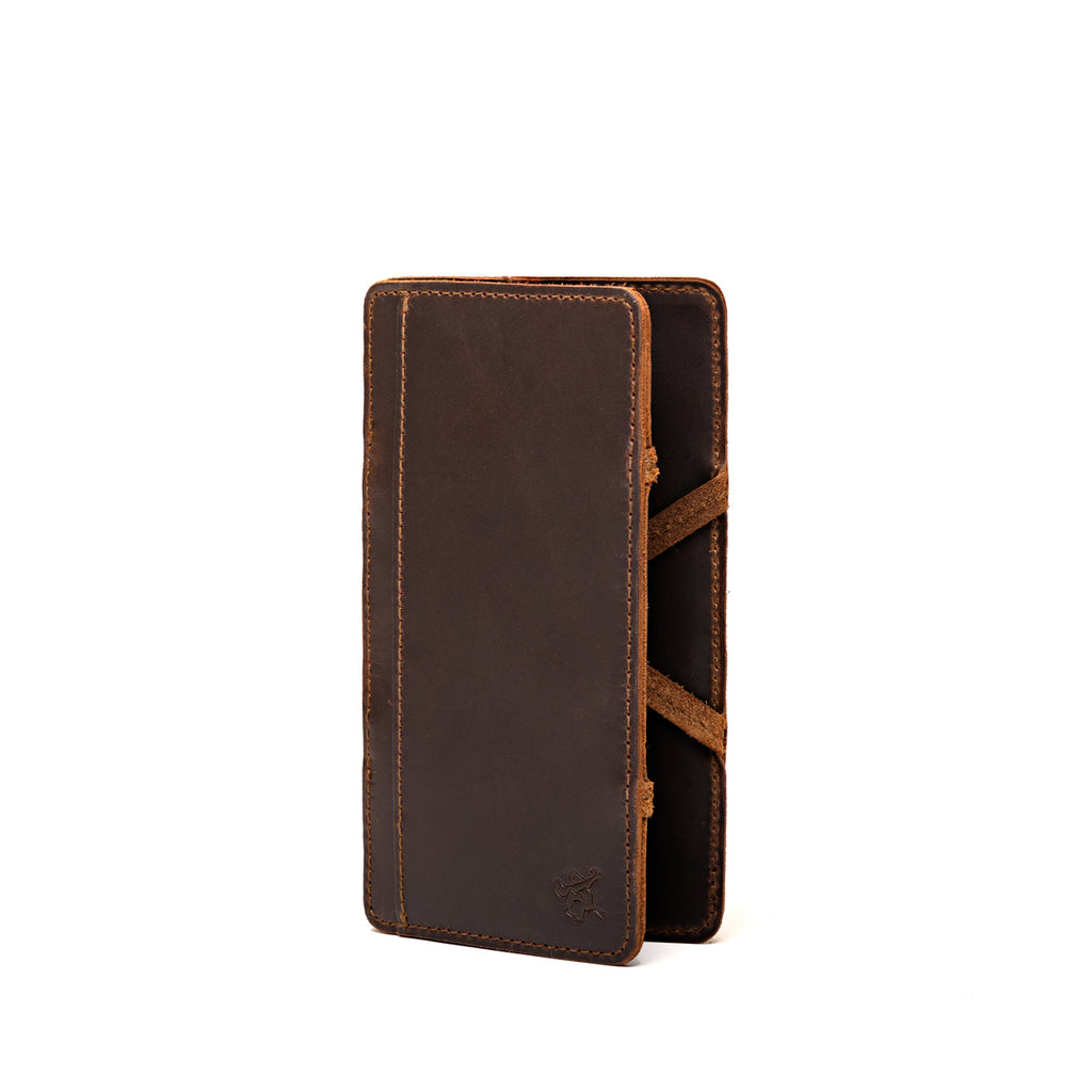 Large Magic Wallet in Dark Coffee Brown standing upright and closed, showing the tall slim profile and side straps