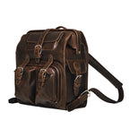 Big Mouth Leather Backpack in Dark Coffee Brown, angled front view with buckled pockets and shoulder strap