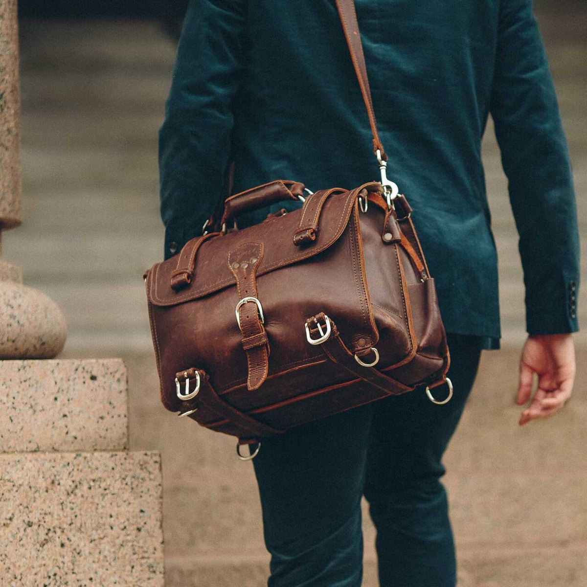 Man in a suit carrying a brown Classic Leather Briefcase on its shoulder strap as a lawyer's bag