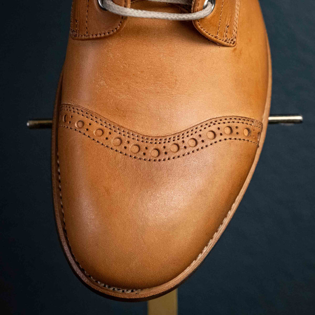 Top-down detail of the brogued toe cap on a high quality English tan leather Officer's Boot
