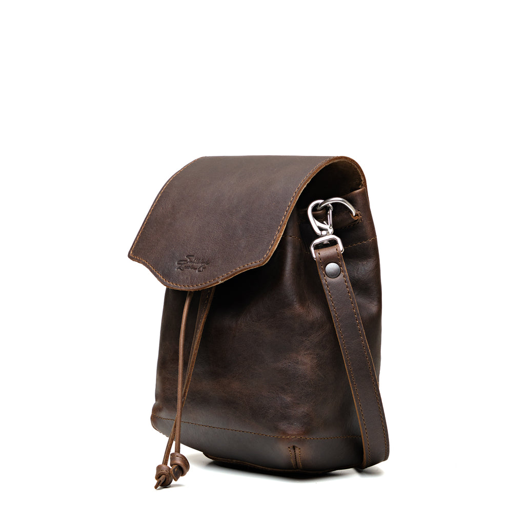 Mini Bucket Bag in Dark Coffee Brown, angled side view with flap, drawstring and strap clip