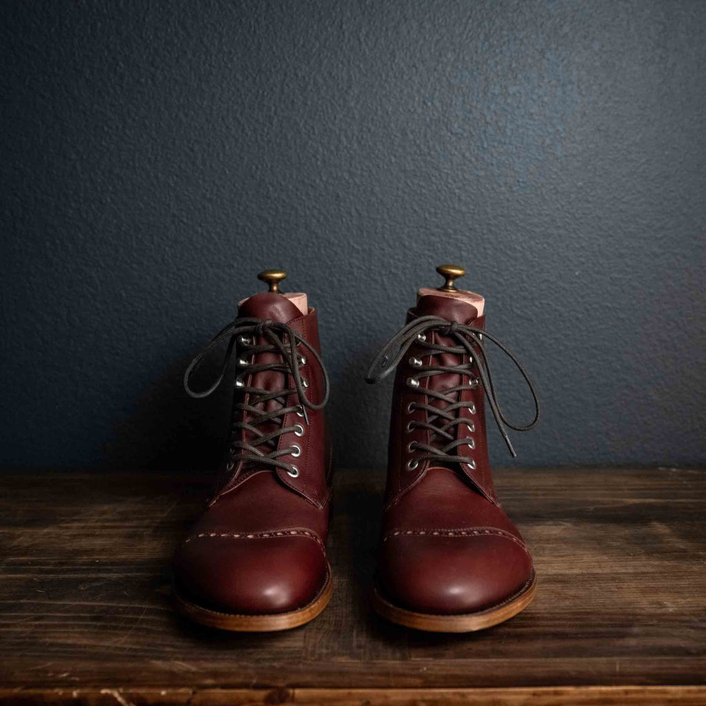Officer Boot in Oxblood, front view of pair with dark laces and brogue cap toes