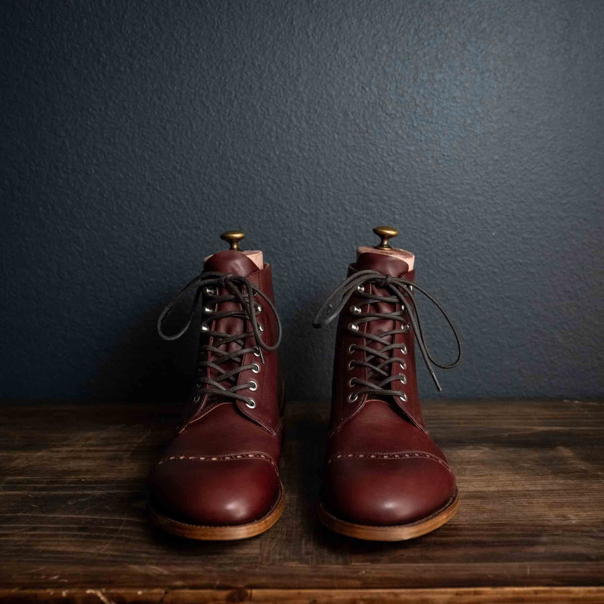 Officer Boot in Oxblood, front view of pair with dark laces and boot trees