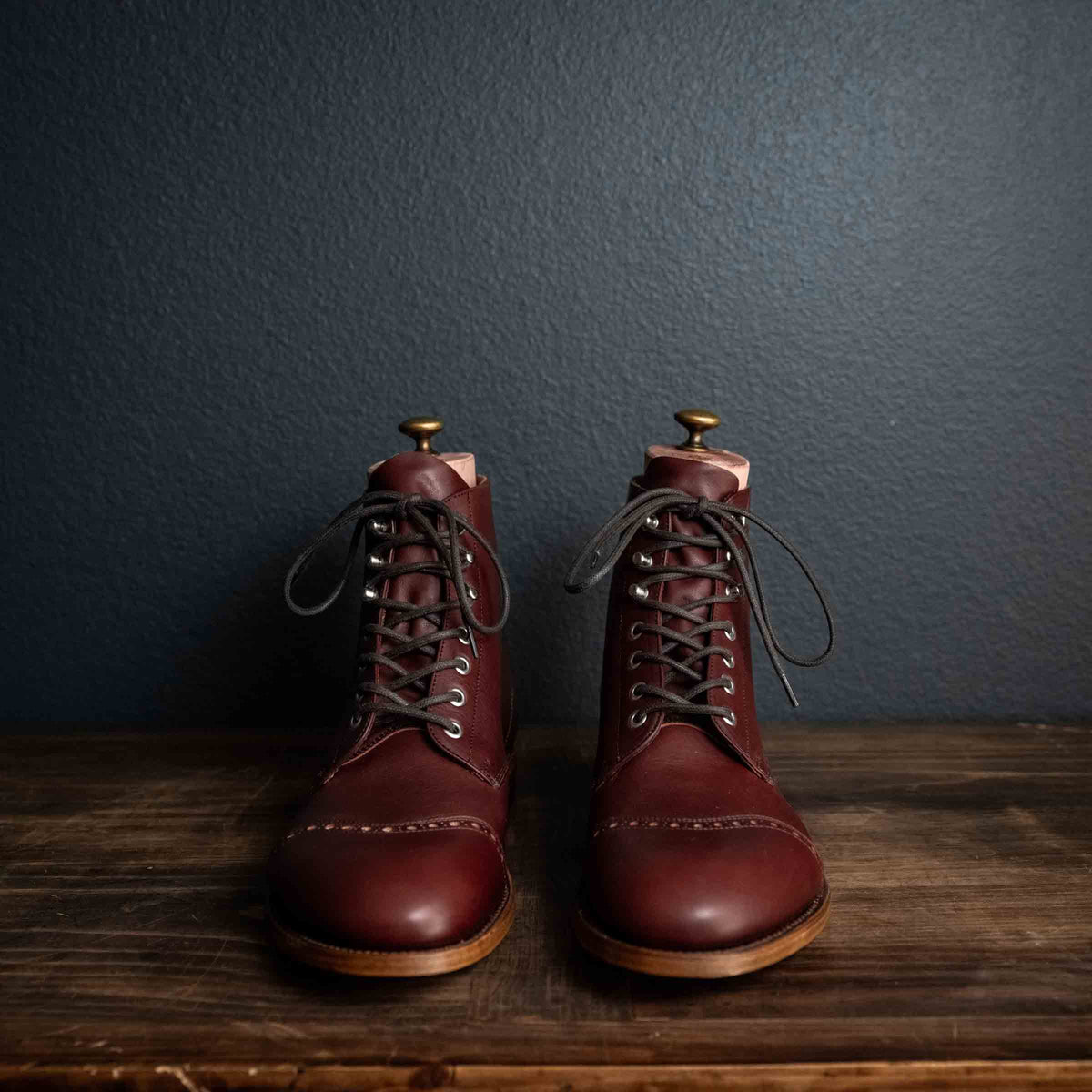 Officer's Boot in Oxblood, front view of the pair with dark laces and shoe trees