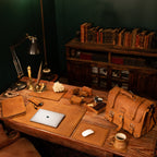 Desk Pad in Tobacco with a laptop on a rustic desk in a lamplit study, beside a leather briefcase and bookshelves