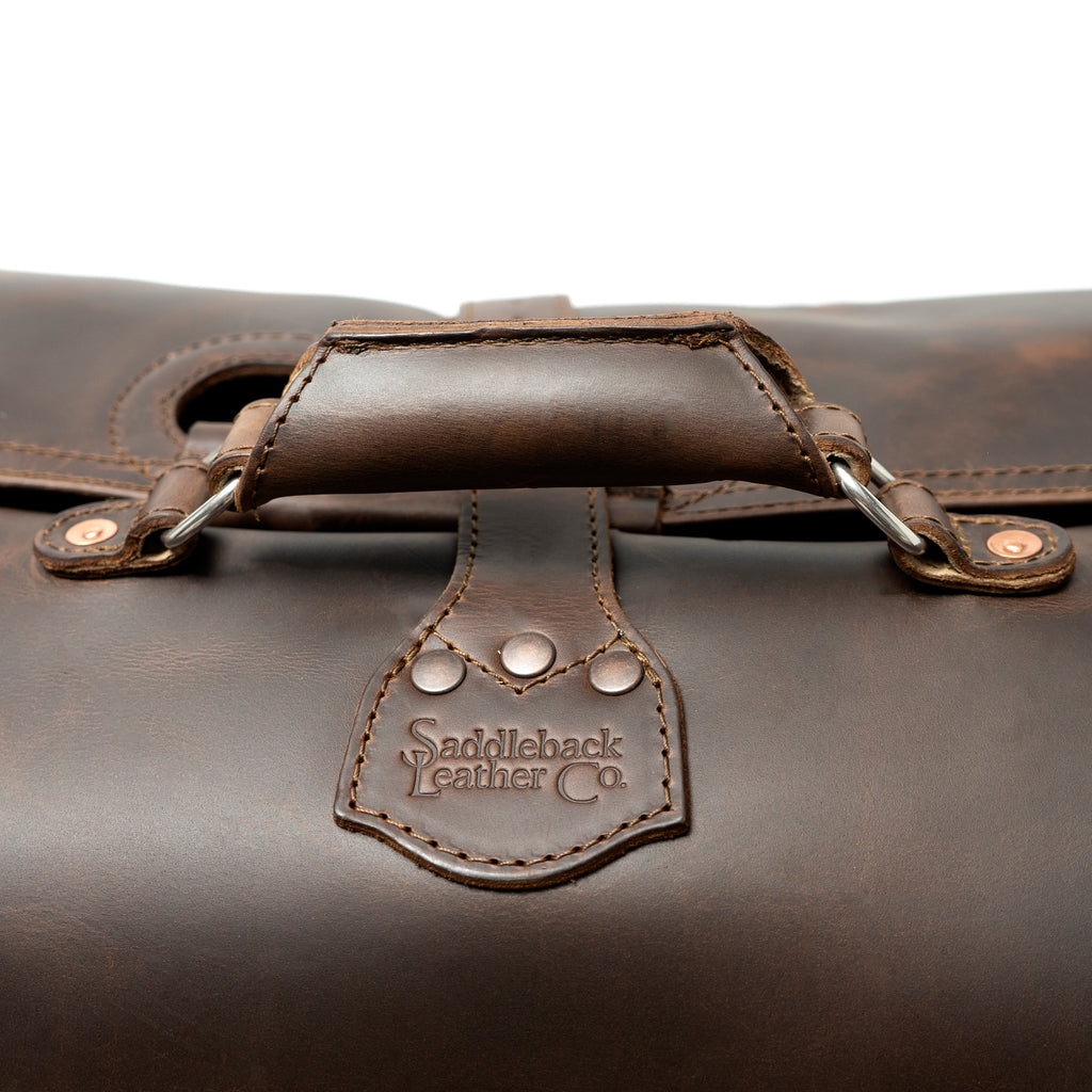 24" Waterbag in dark brown, close-up of the padded top handle and riveted logo tab