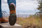 Huntsman Boots in brown leather, heel raised mid-step to show the lug sole on a stone ledge