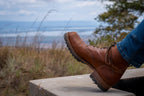 Huntsman Boots in brown leather, close-up of toe and laces resting on a concrete ledge outdoors