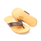 Flip Flops in Chestnut leather, one upright and one flipped to show the logo-embossed sole