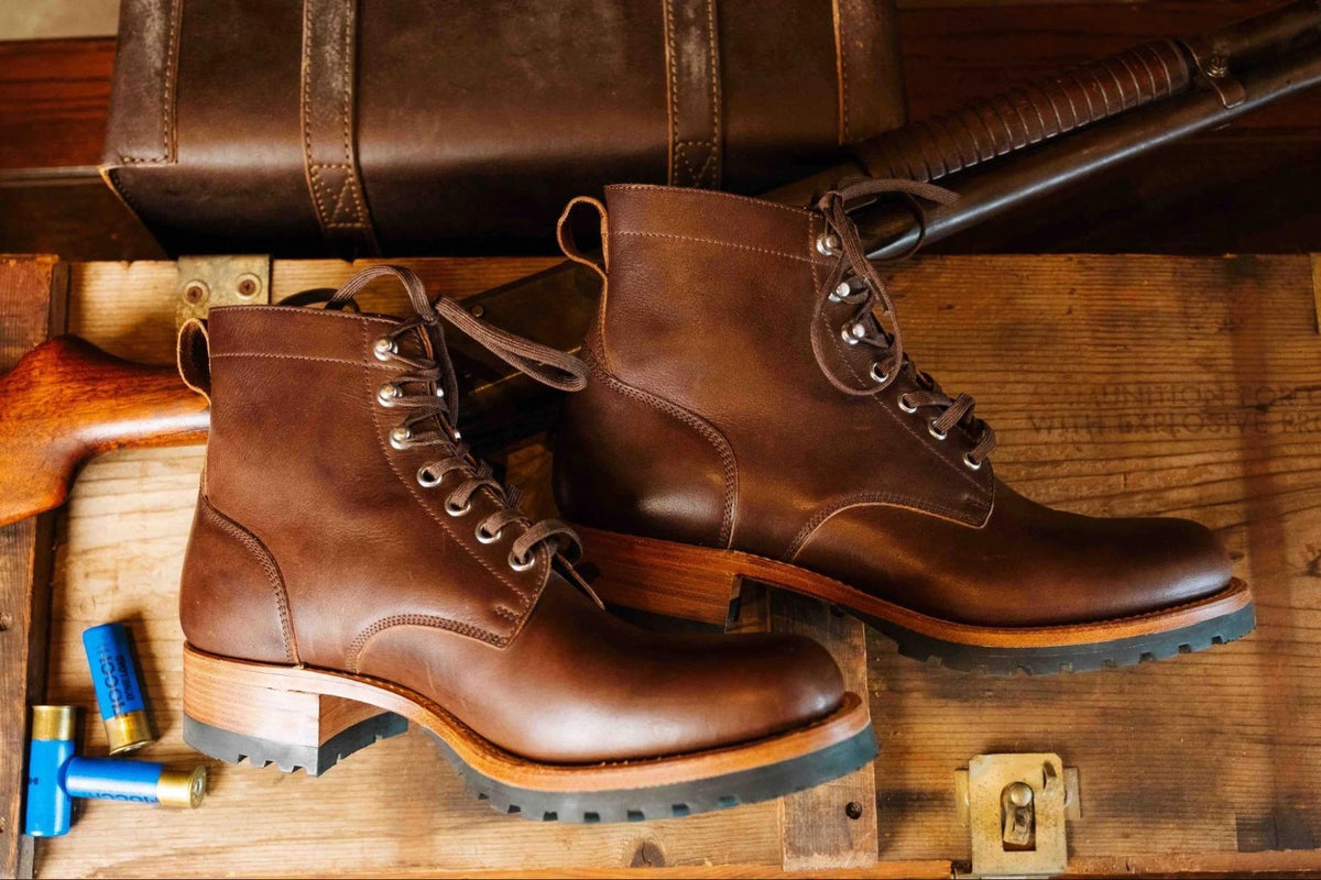Huntsman Boots - Dark Coffee Brown, overhead view of a pair on a wooden crate beside a leather case
