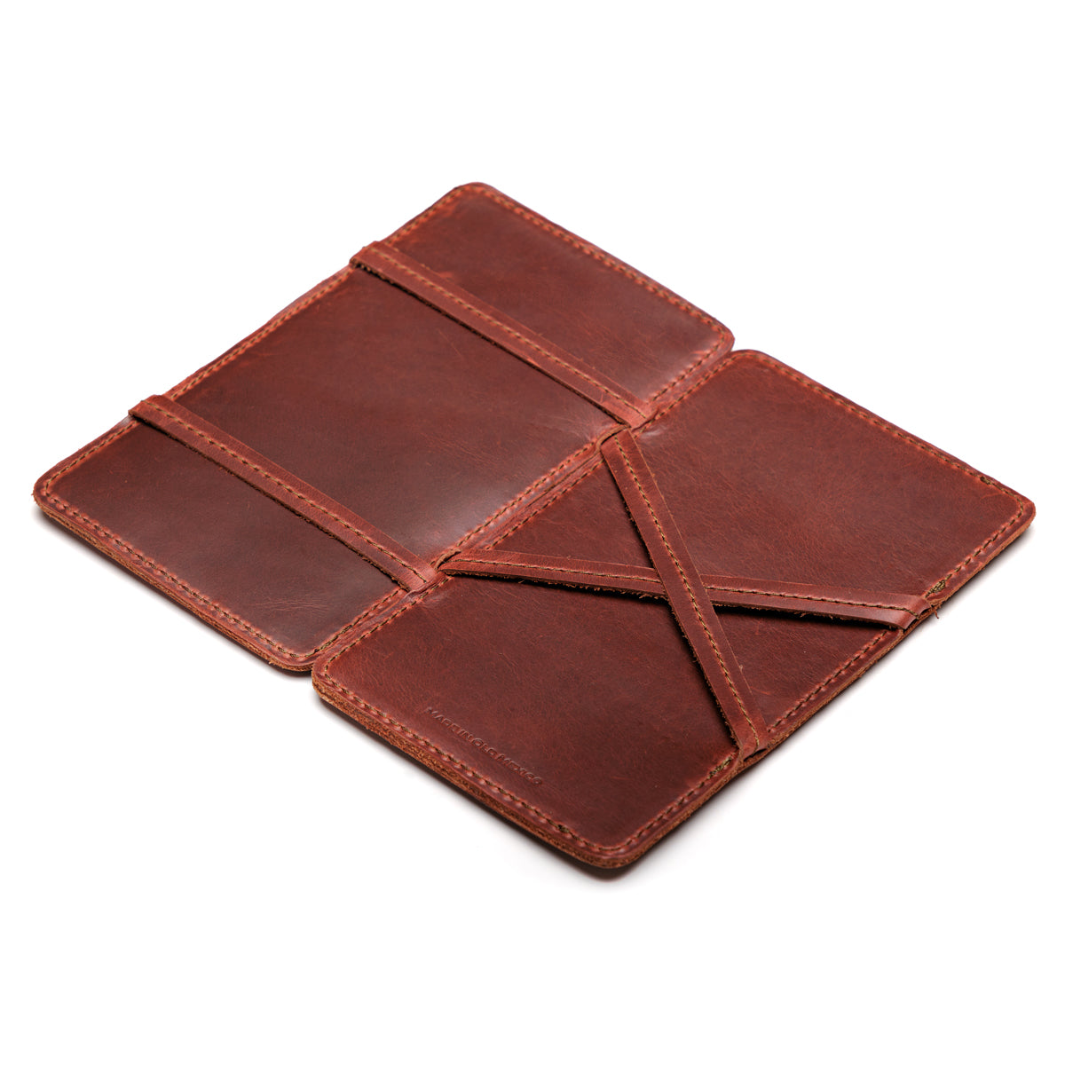 Large Magic Wallet in Chestnut opened flat to show the crossed leather straps inside