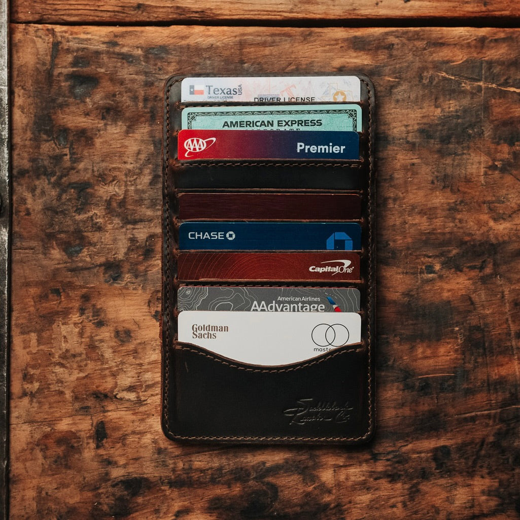 Large Magic Wallet in Dark Coffee Brown on a rustic wood table with every card slot filled
