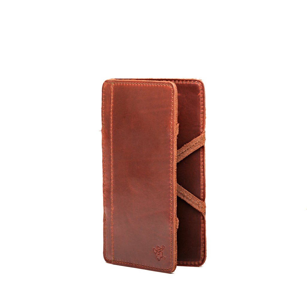 Large Magic Wallet in Chestnut standing upright and closed, showing the tall slim profile and side straps