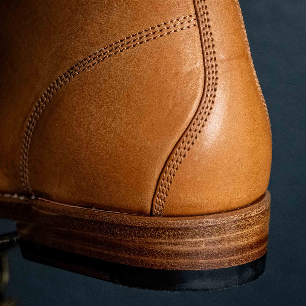 Close detail of the stacked leather heel on a high quality English tan leather Officer's Boot, rear side view